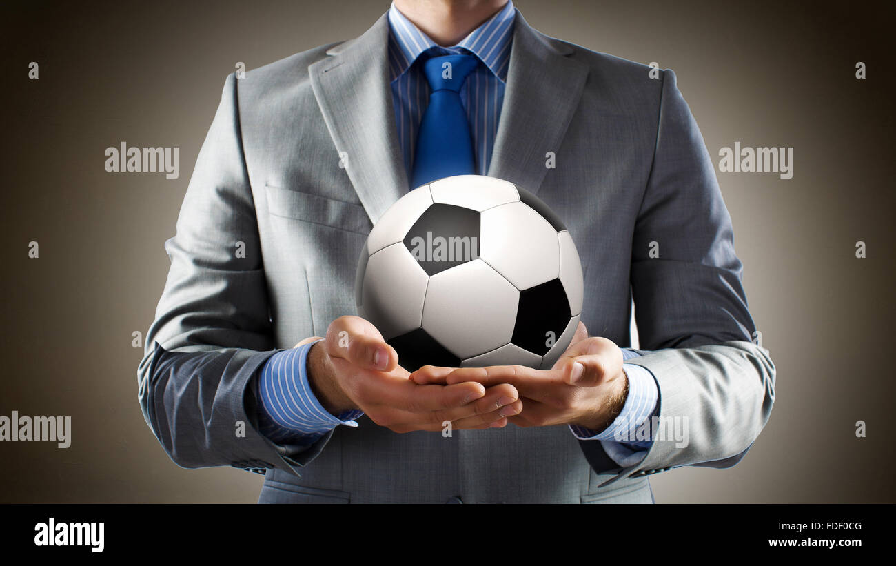 Close up of businessman holding soccer ball in hand Stock Photo - Alamy
