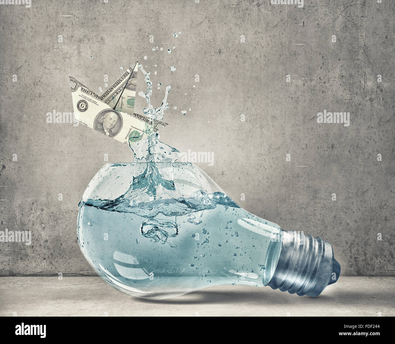 Glass light bulb filled with water and dollar ship floating inside