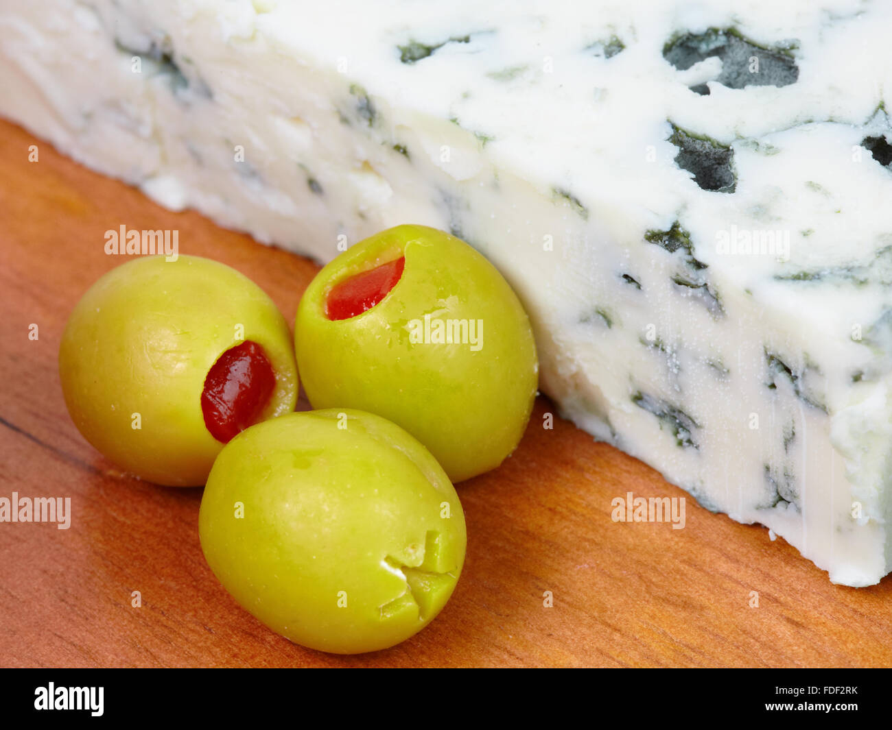 Close-up of blue cheese with green olives. Stock Photo