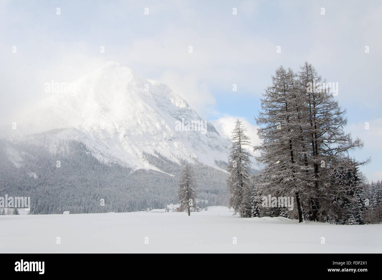 A snow covered mountain peak on a  cold winter day in the alps Stock Photo