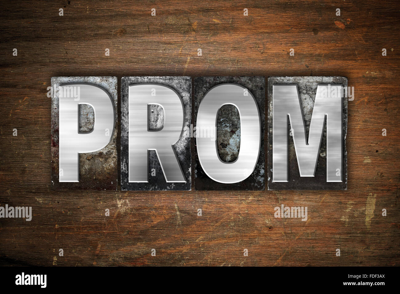 The word 'Prom' written in vintage metal letterpress type on an aged wooden background. Stock Photo