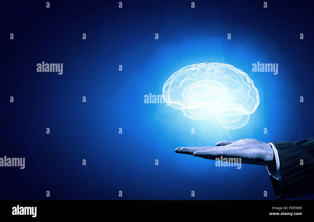 Close up of human hand holding brain on blue background Stock Photo - Alamy