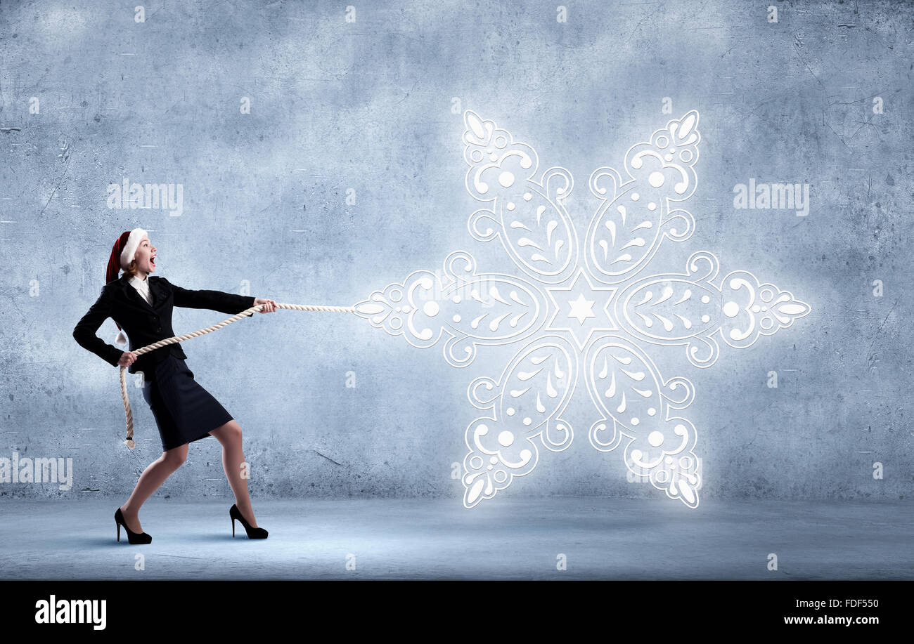 Santa woman pulling white snowflake on rope Stock Photo - Alamy