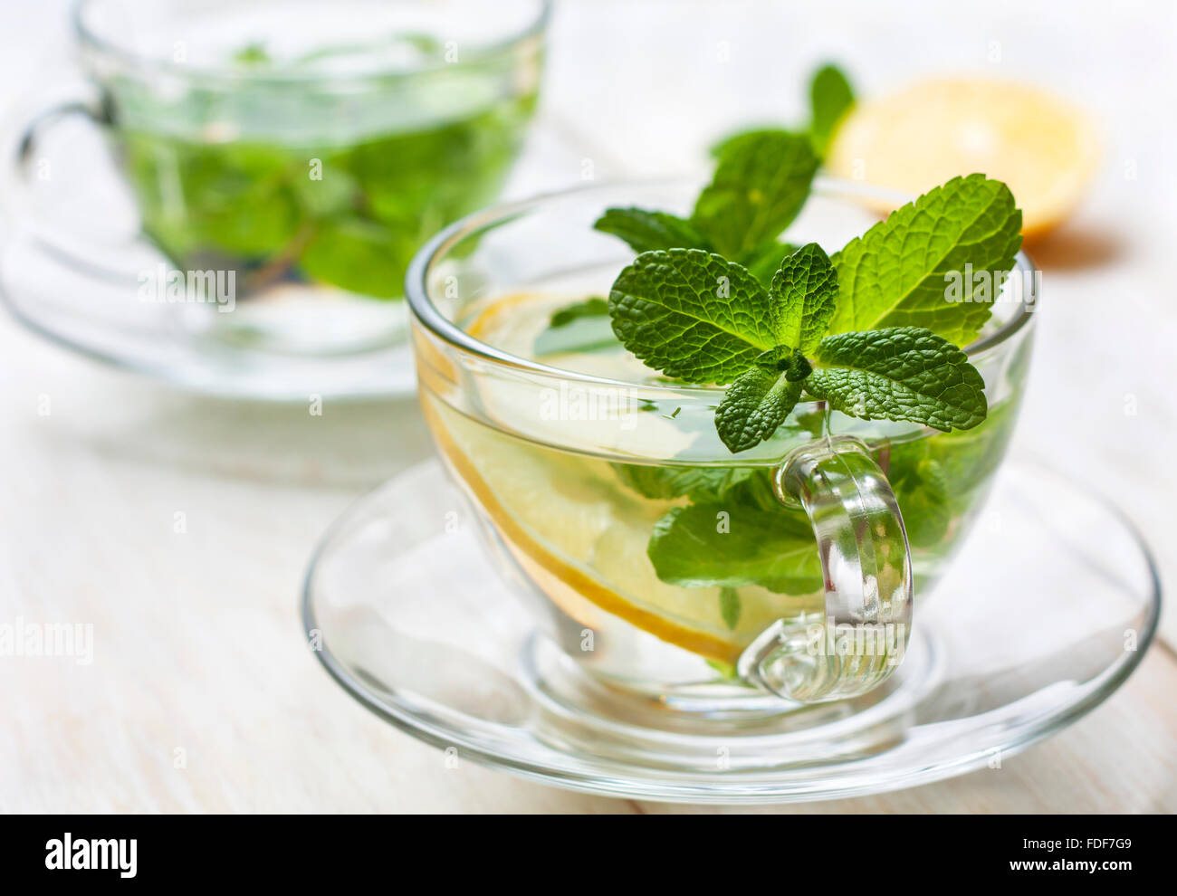 cups of tea with fresh mint and lemon slices on a blue wooden background Stock Photo