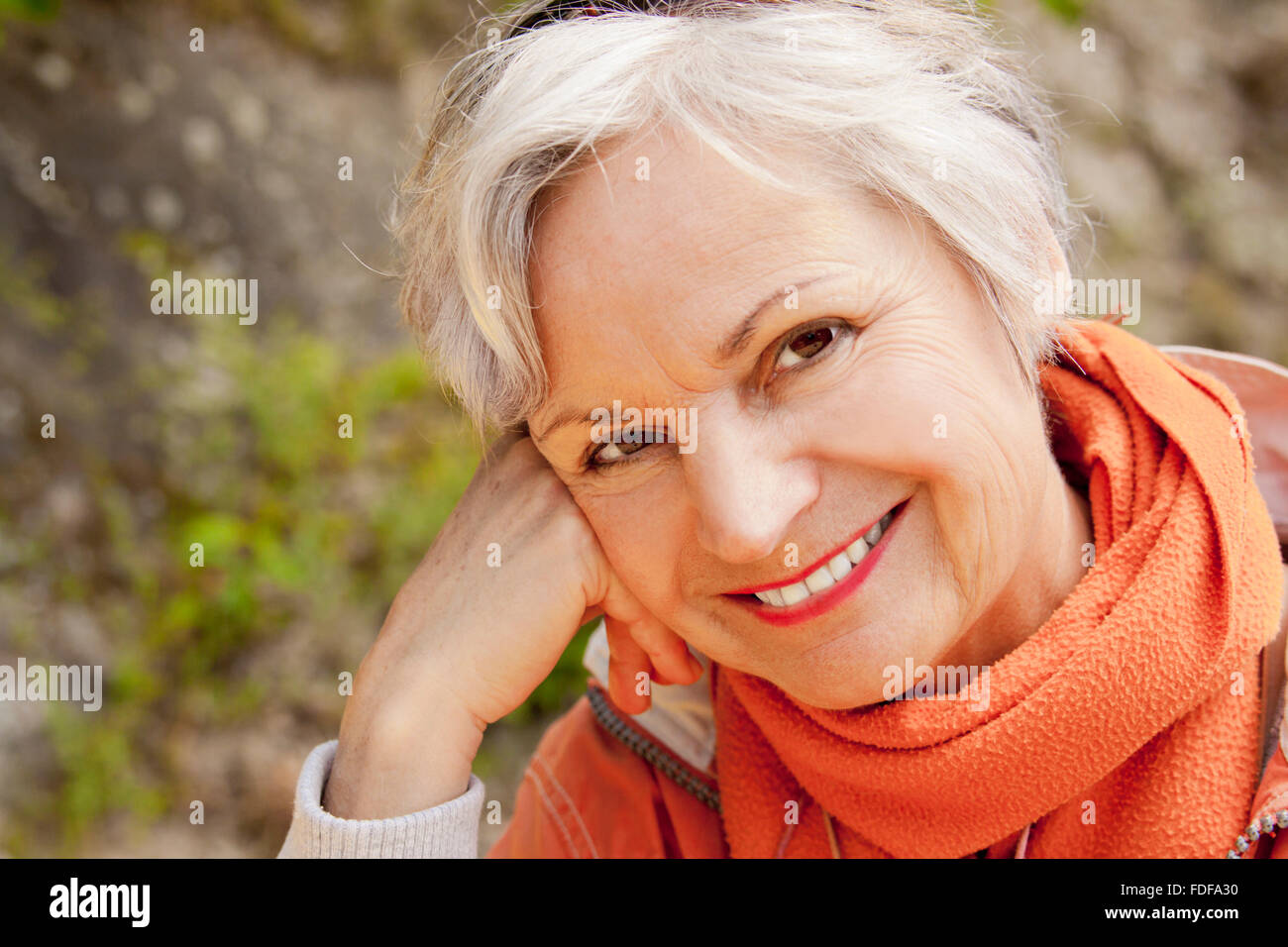 attractive senior old woman smiling thoughtful outdoors Stock Photo