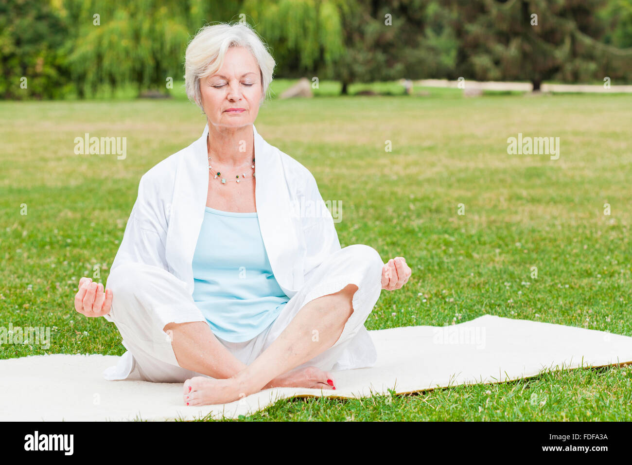 a very beautiful old lady doing yoga wearing a sports