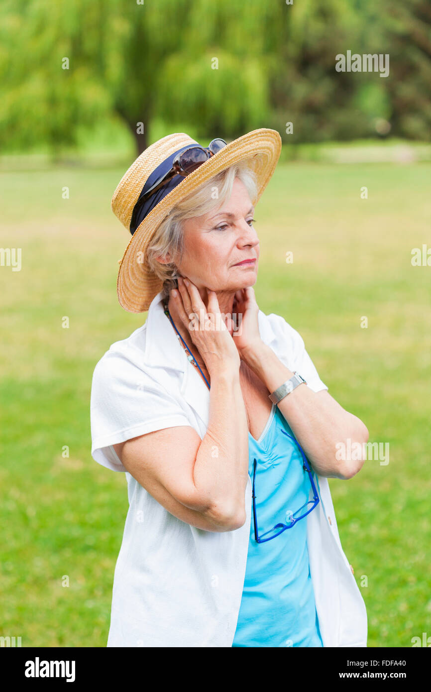 attractive senior old woman smiling thoughtful outdoors Stock Photo