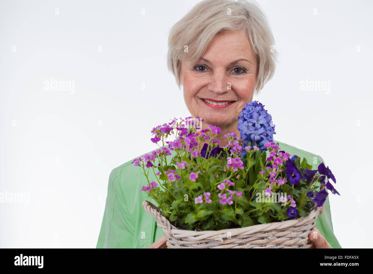 happy old senior woman on mothers day holding flowers smiling big smile Stock Photo