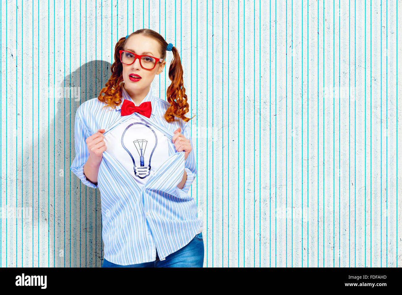 Young woman acting like super hero with bulb illustration on chest Stock Photo