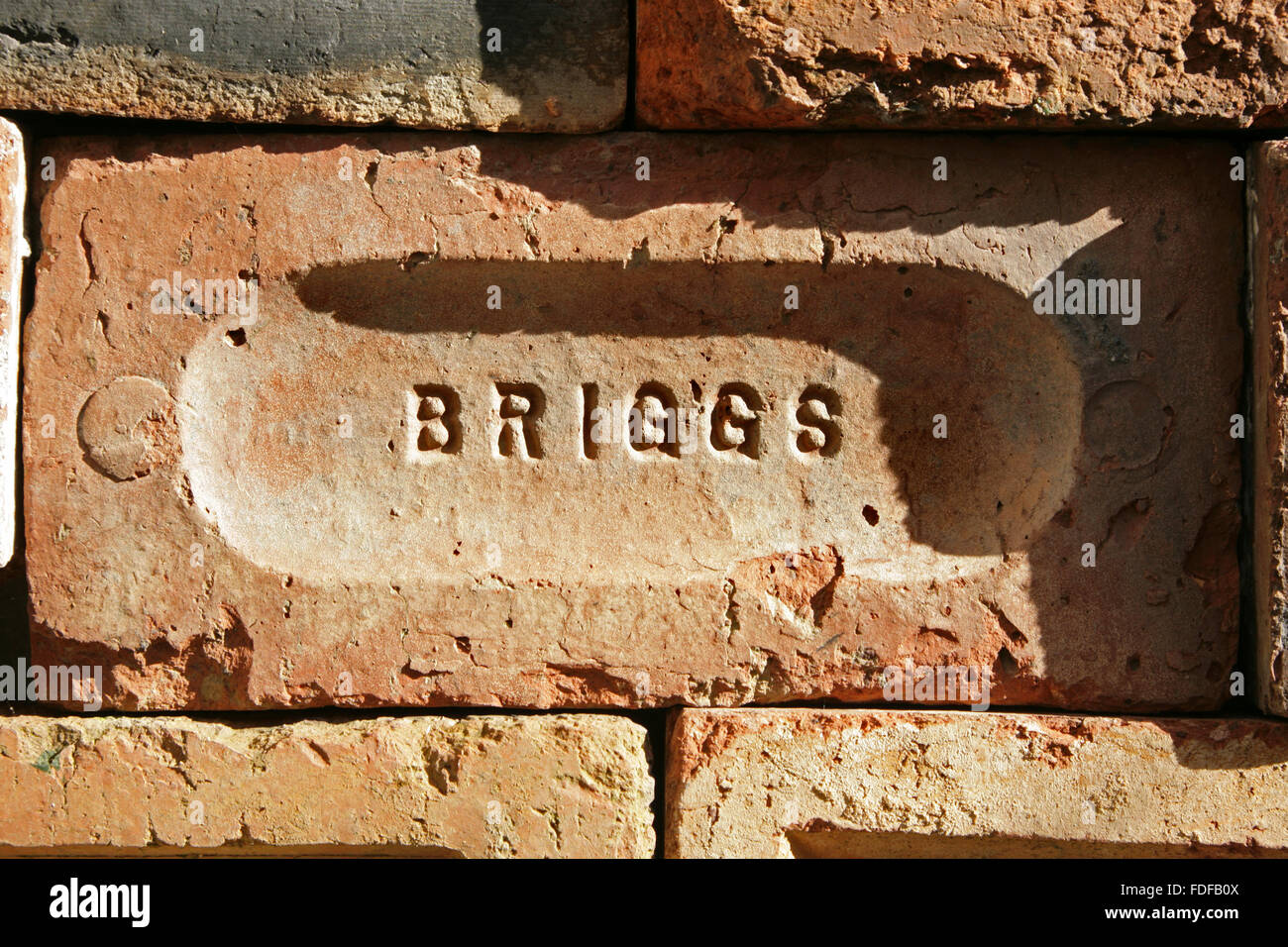 Old brick with 'Briggs' imprinted into the face. Stock Photo