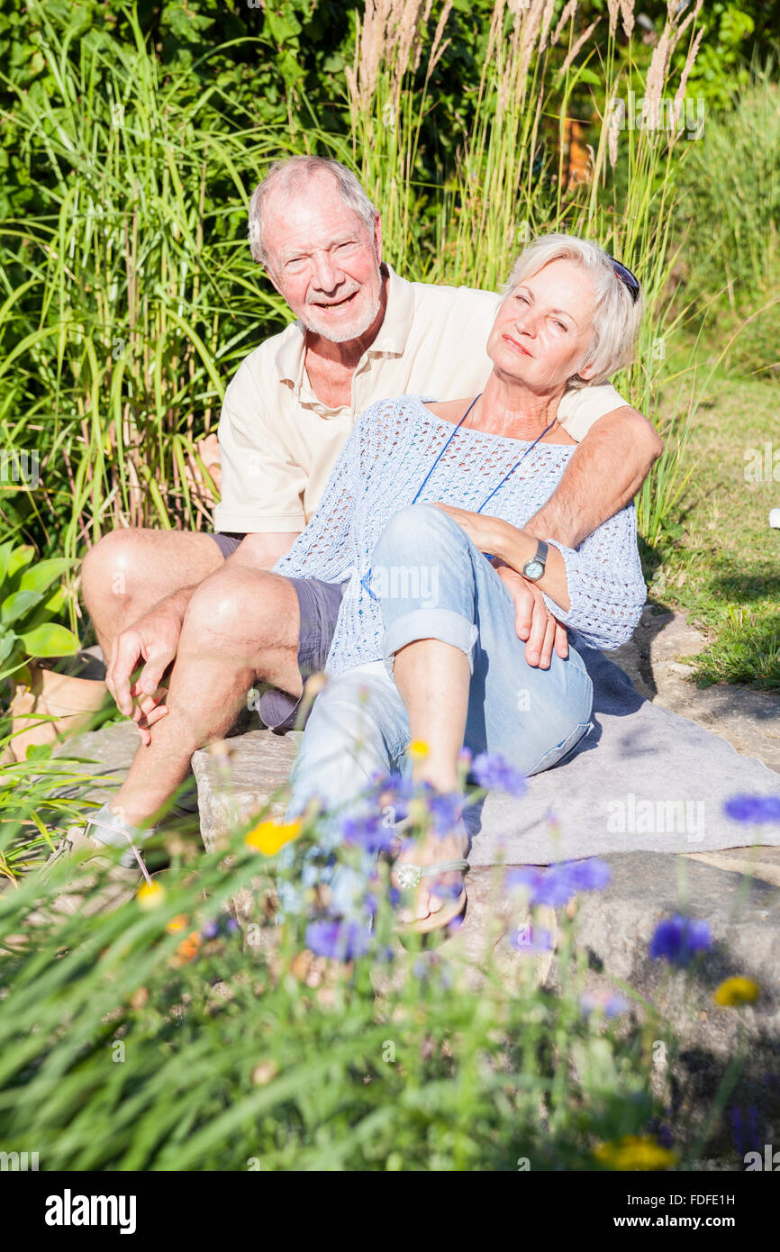 happy senior couple in garden smiling and laughing in sunshine enjoying retirement Stock Photo
