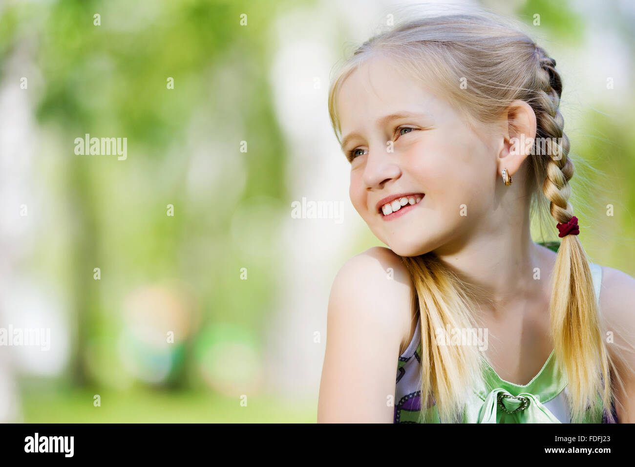 Image of little cute girl sitting on grass in park Stock Photo - Alamy