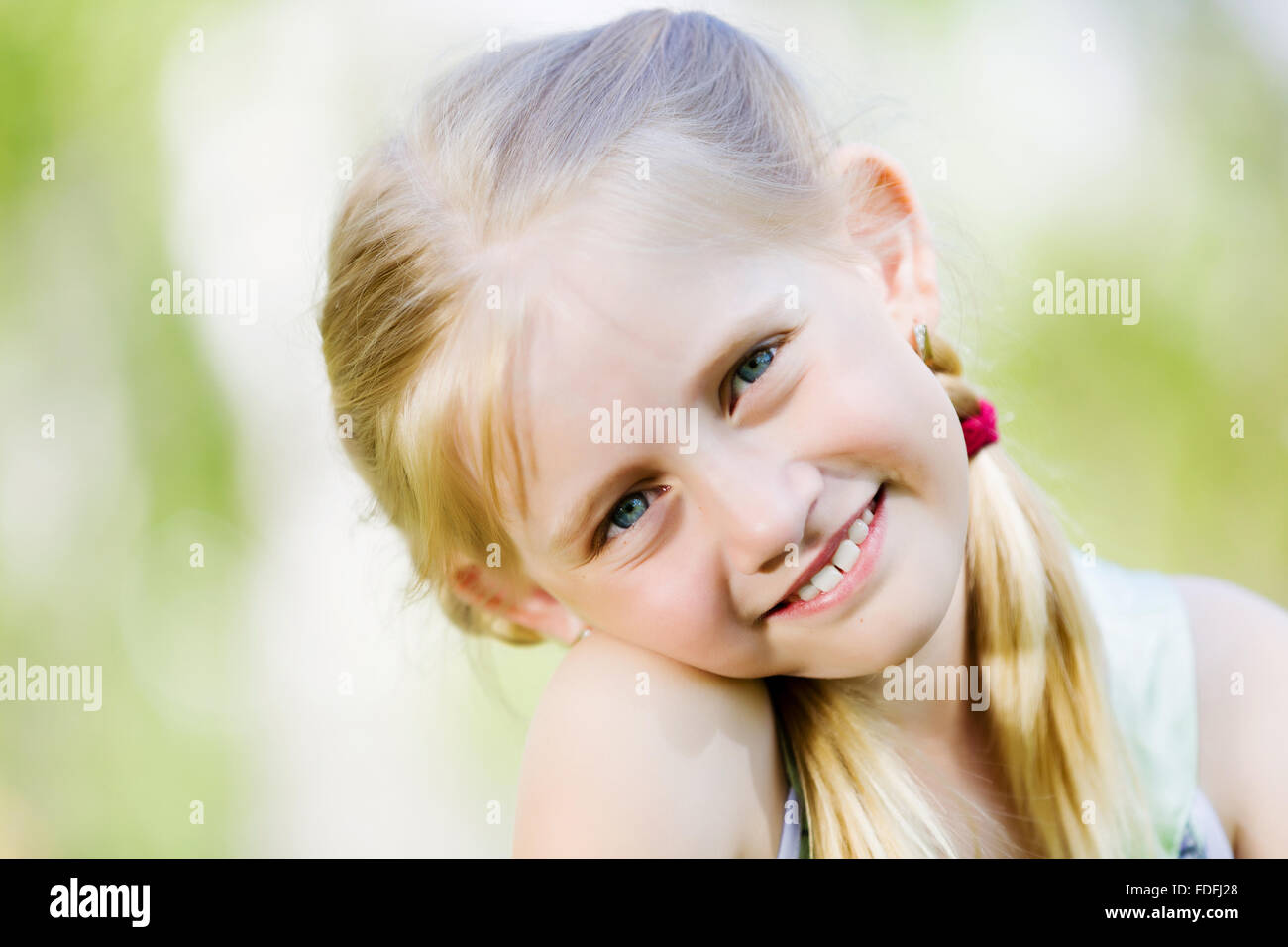 Image of little cute girl sitting on grass in park Stock Photo - Alamy