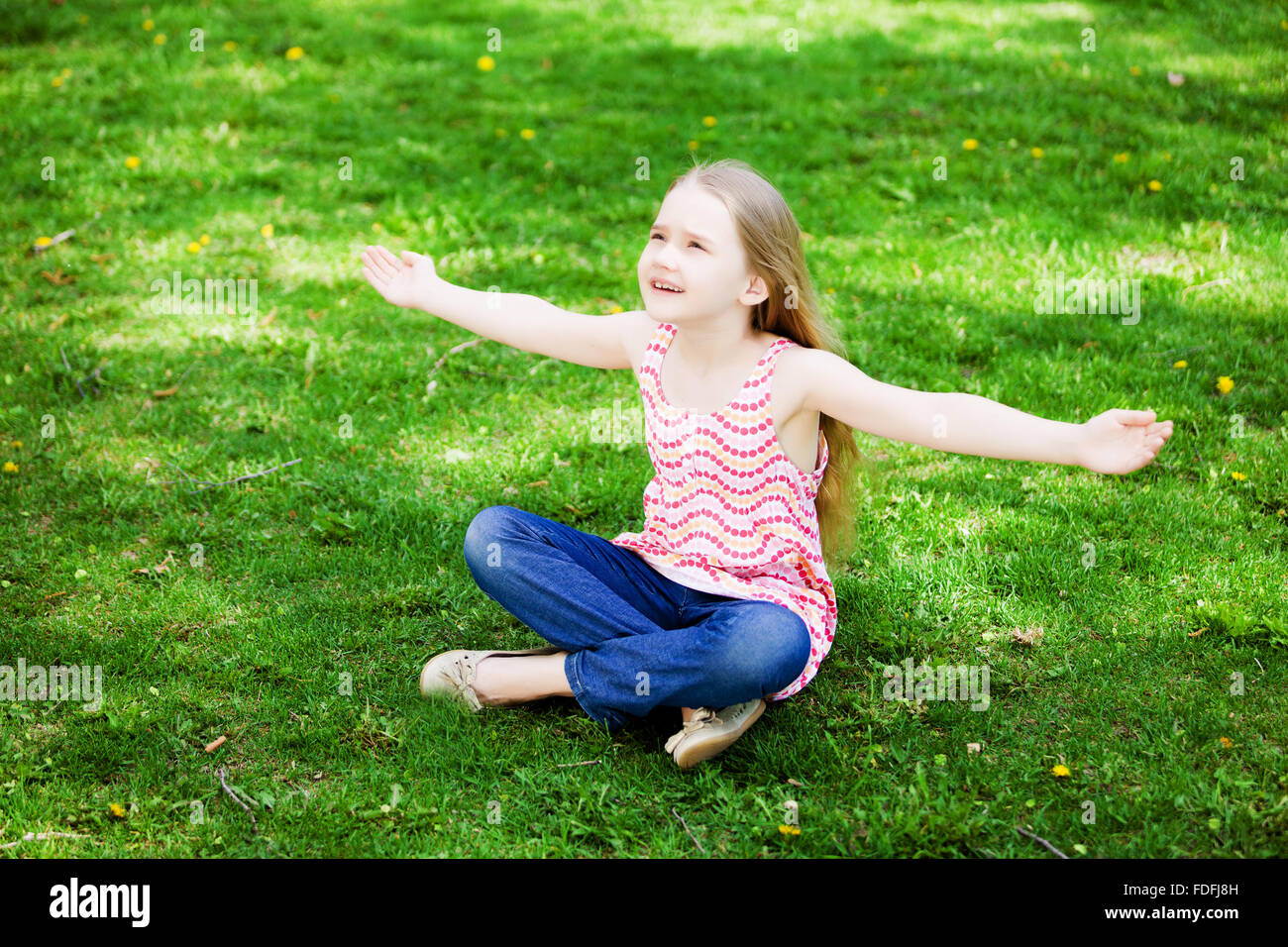 Image of little cute girl sitting on grass in park Stock Photo - Alamy