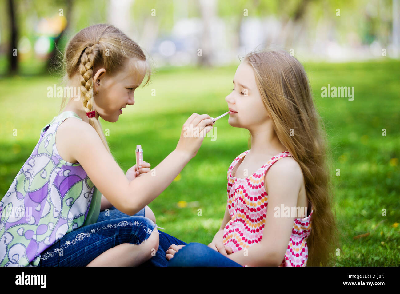 Image of two little cute girl playing on grass in park Stock Photo - Alamy