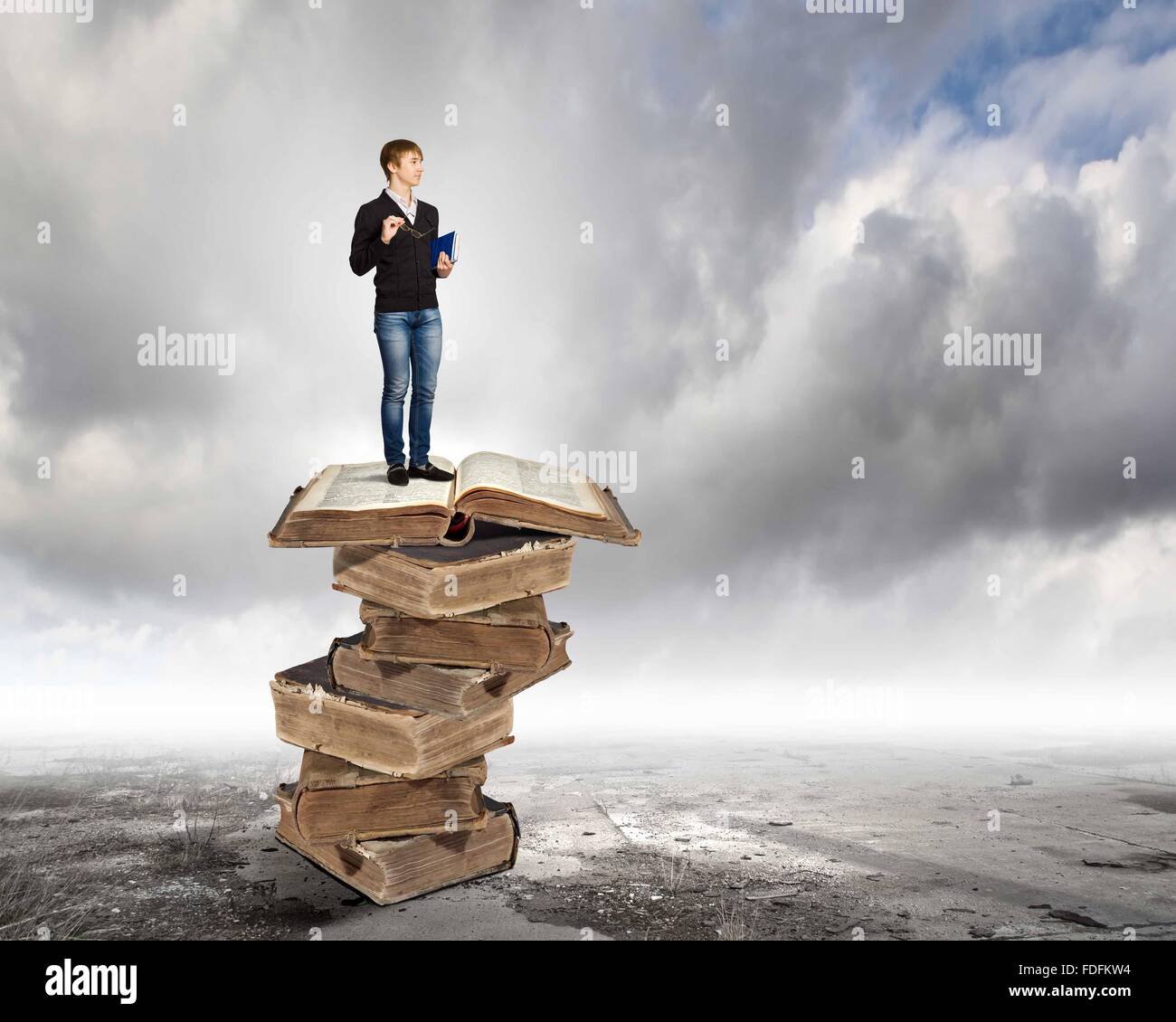 Image of little cute boy standing on pile of books Stock Photo - Alamy
