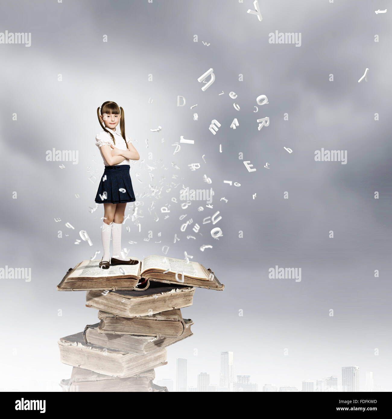 Image of cute school girl standing on pile of books Stock Photo - Alamy