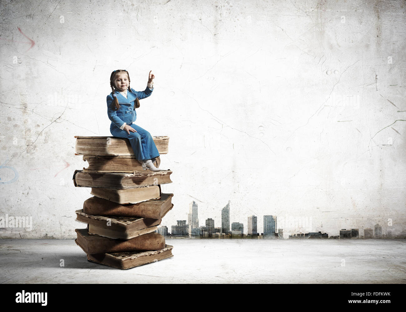 Image of cute school girl in sitting on pile of books Stock Photo - Alamy