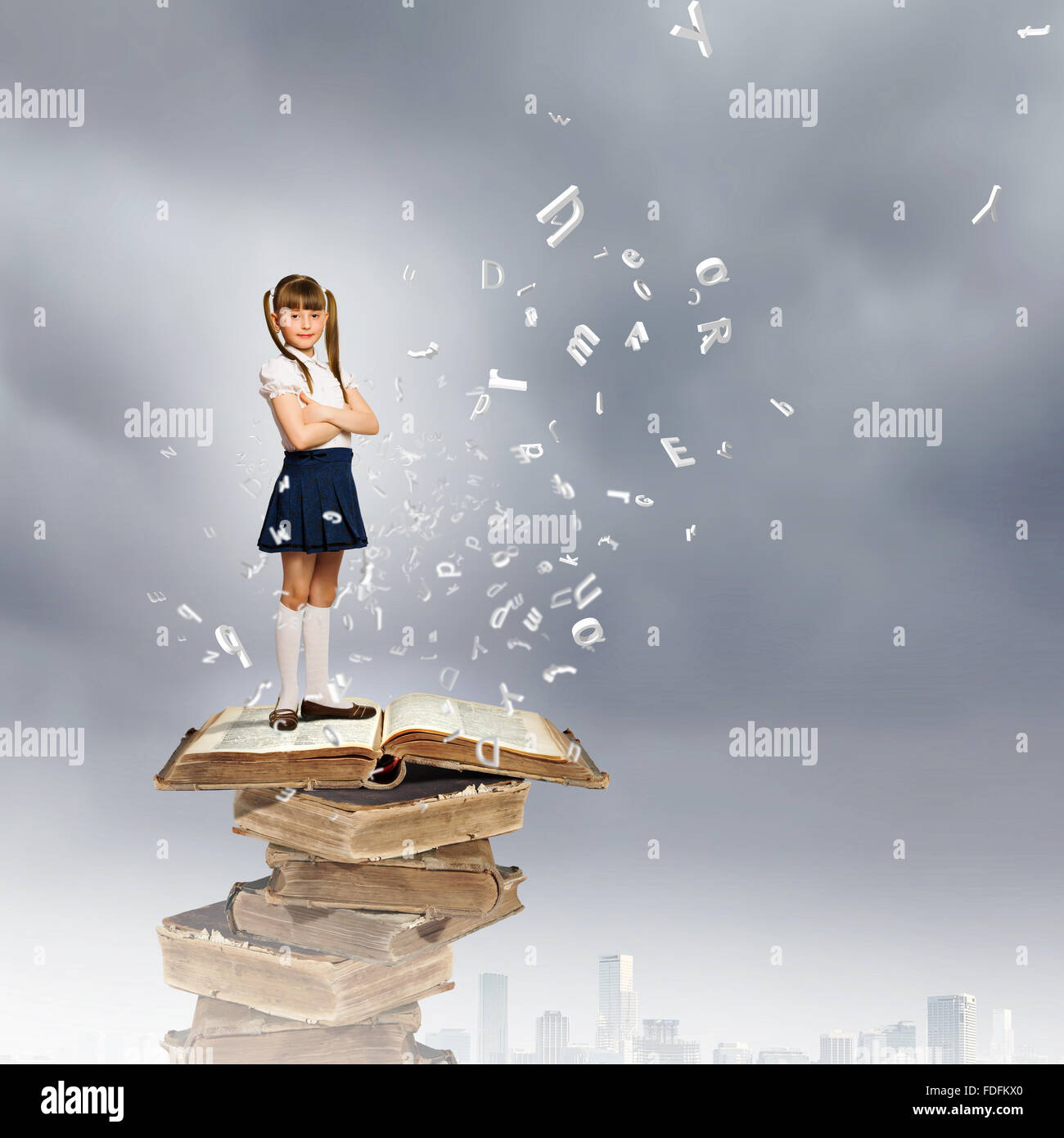 Image of cute school girl standing on pile of books Stock Photo - Alamy