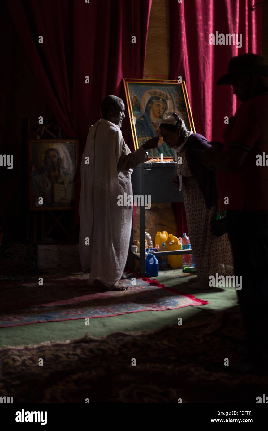 Red curtains catch the low light inside a stone-cut church near Mekele in Ethiopia Stock Photo