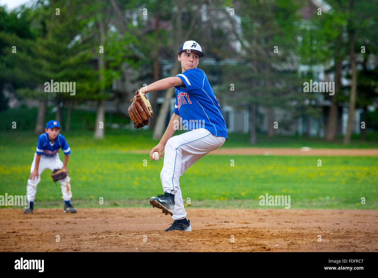 Little league baseball pitcher age 12 winding up his pitch on the mound. St Paul Minnesota MN USA Stock Photo