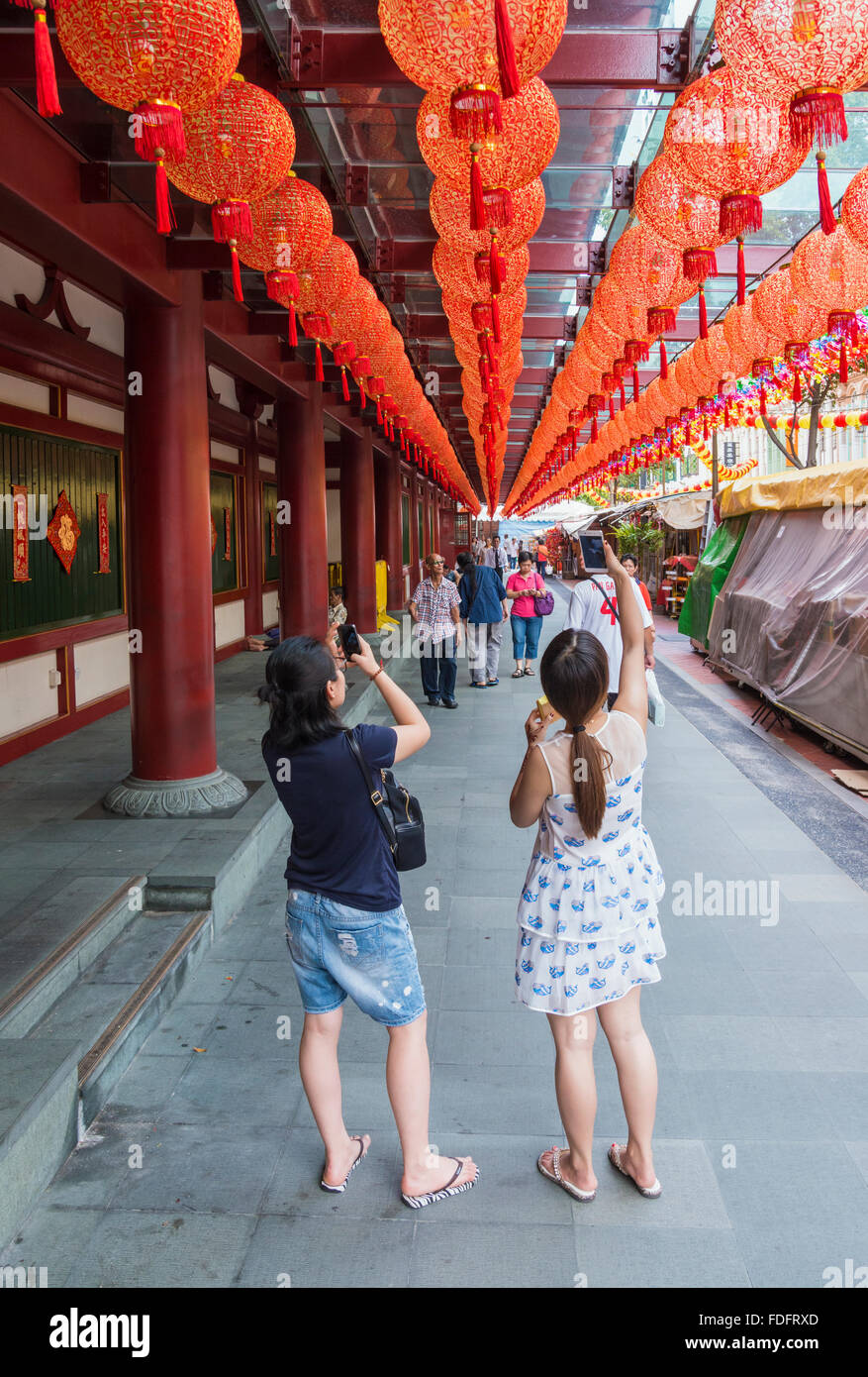 People taking photos of the red lanterns at the Buddha Tooth Relic Temple during Chinese New Year in Chinatown, Singapore Stock Photo