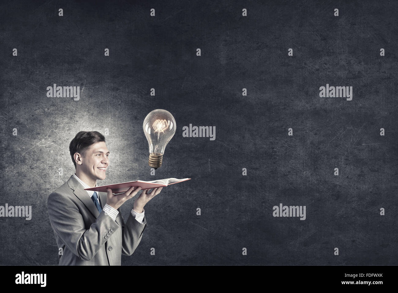 Businessman holding opened book with glass glowing light bulb Stock ...