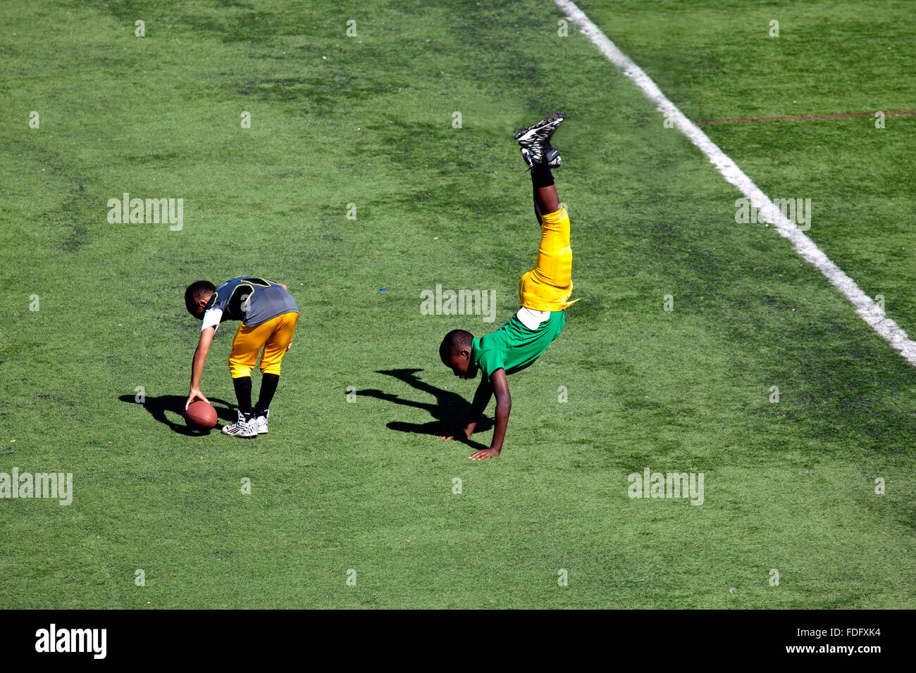 Football acrobats performing cartwheels while warming up for their game. McMurray Field St Paul Minnesota MN USA Stock Photo