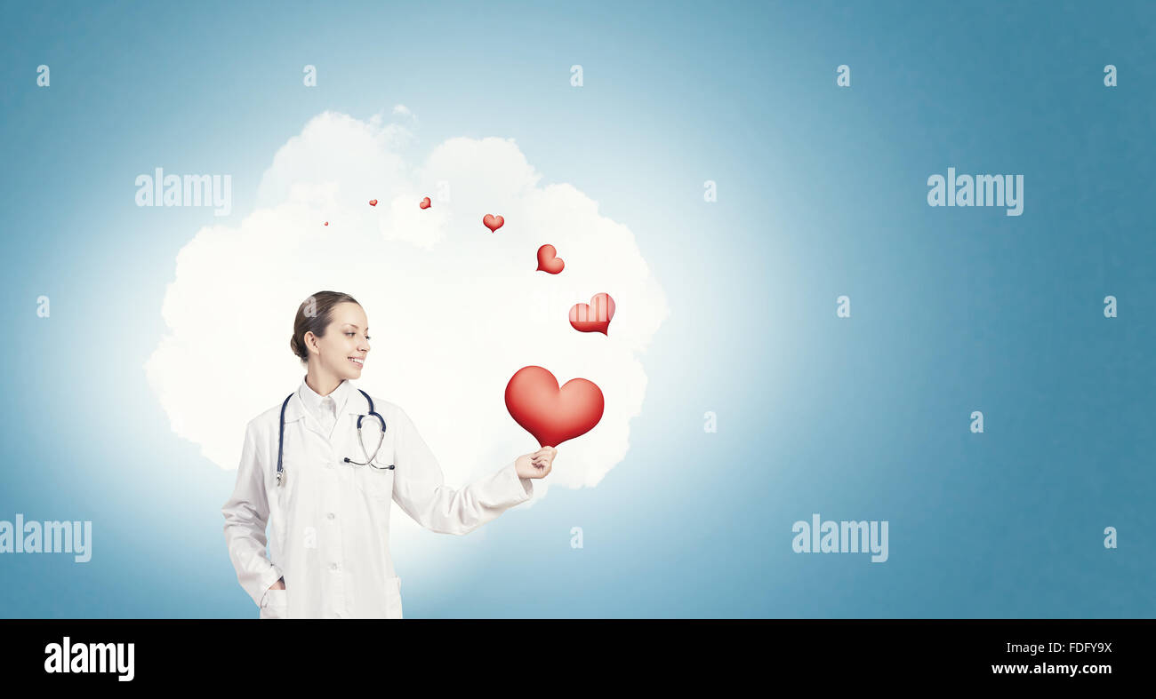 Young female doctor holding red heart in hands Stock Photo - Alamy
