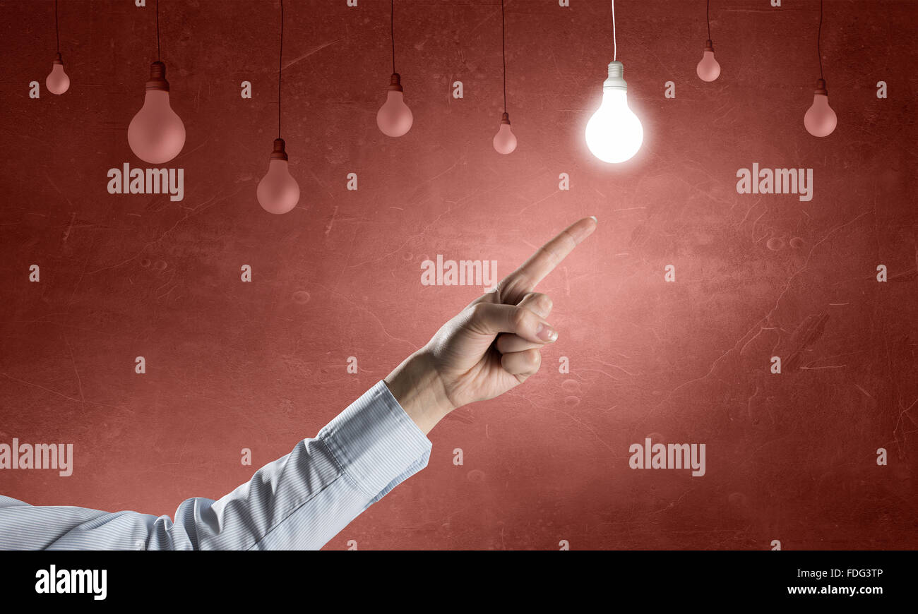 Close up of hand pointing with finger at light bulb Stock Photo - Alamy