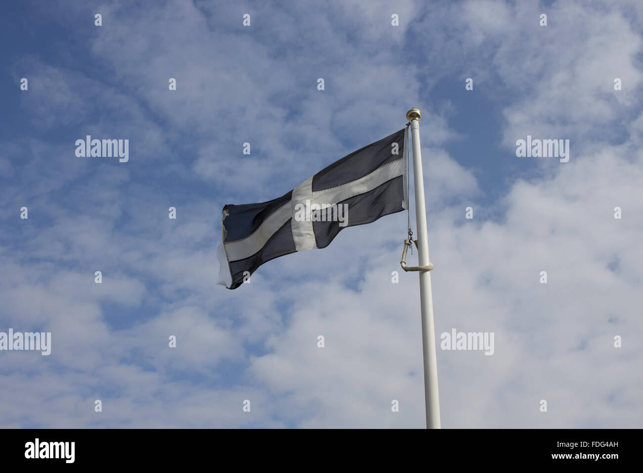 Cornish flag flying against a blue sky Stock Photo
