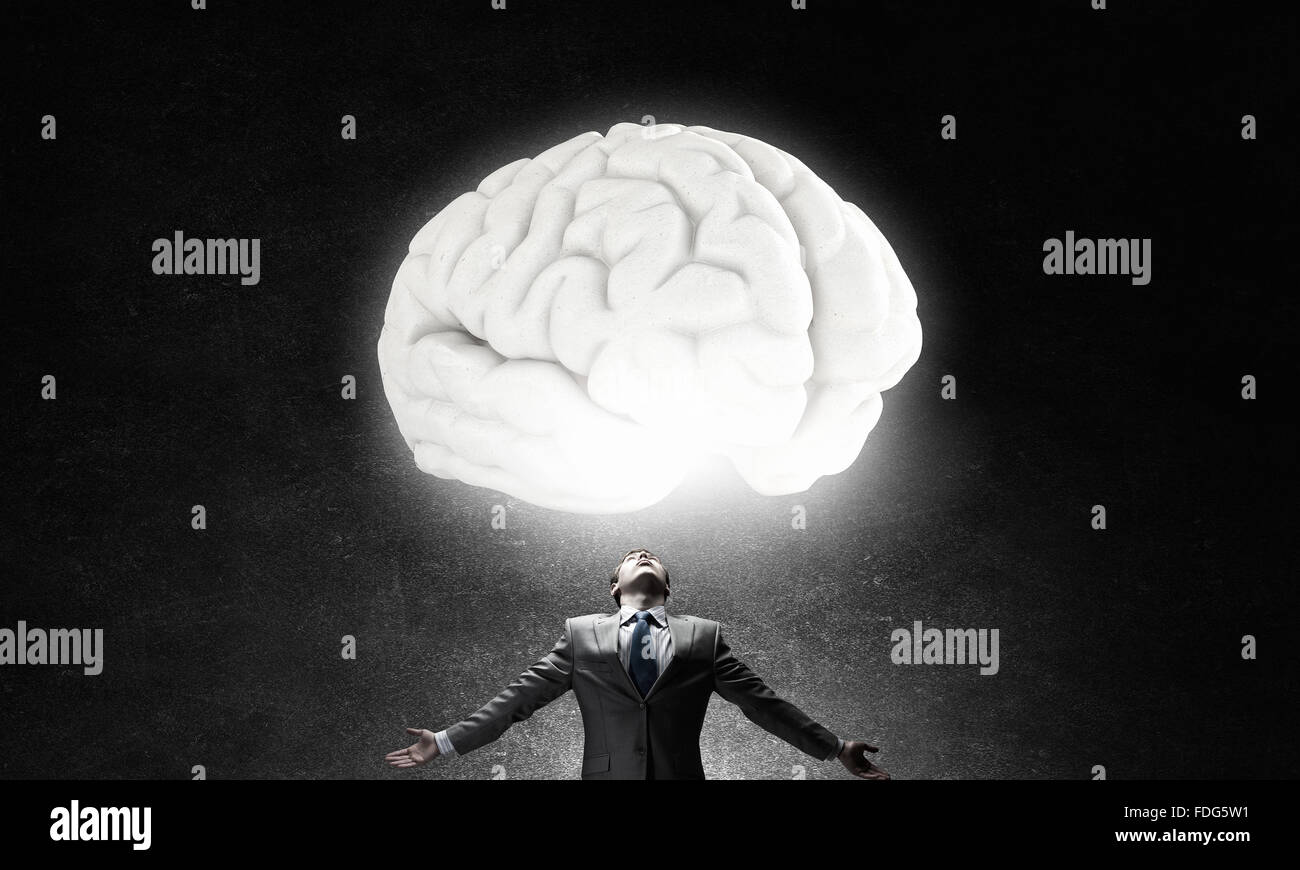 Businessman with hands spread wide and human brain above his head Stock Photo