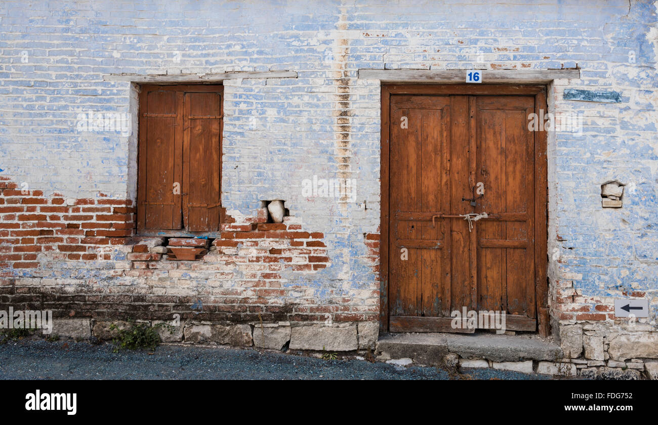 Exterior of an old village house with blue stoned wall and closed ...
