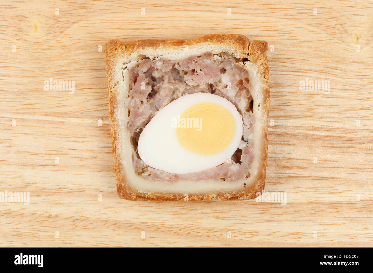 Slice of pork and egg gala pie on a wooden board Stock Photo