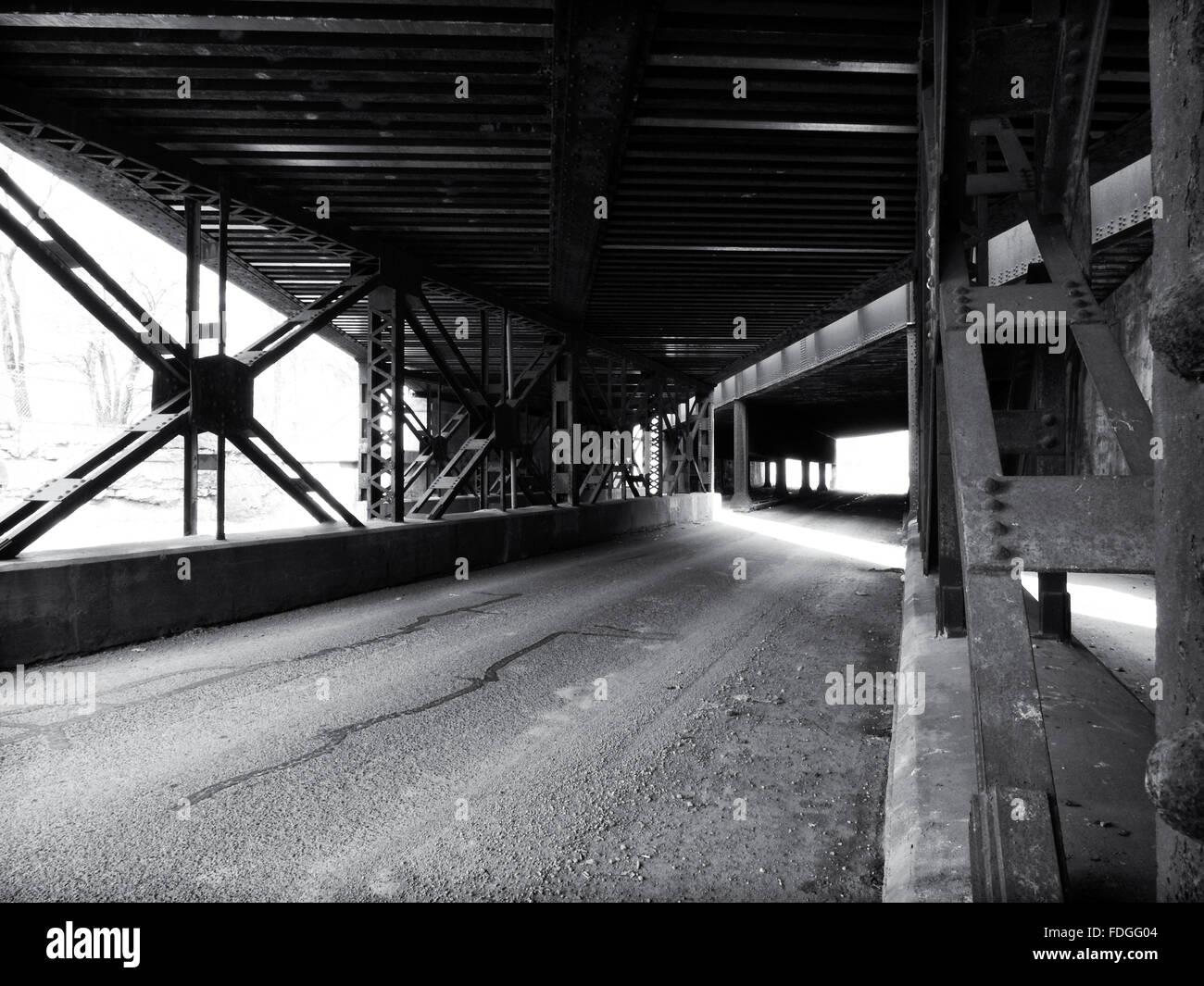 View under the Milwaukee Avenue railroad bridges in Milwaukee Junction Detroit depicting the angles and lines of the steel const Stock Photo
