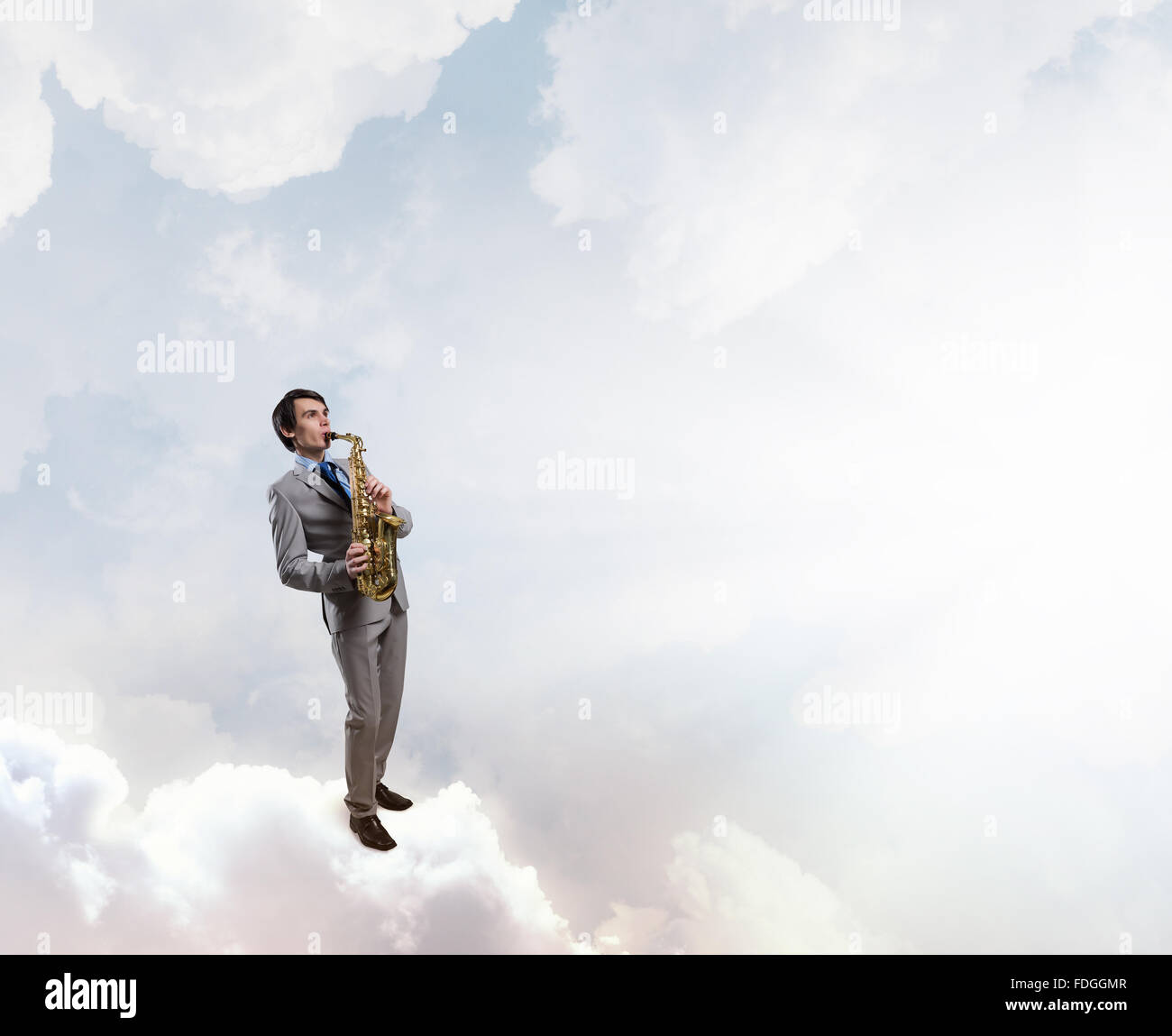 Young man standing on cloud playing saxophone Stock Photo Alamy