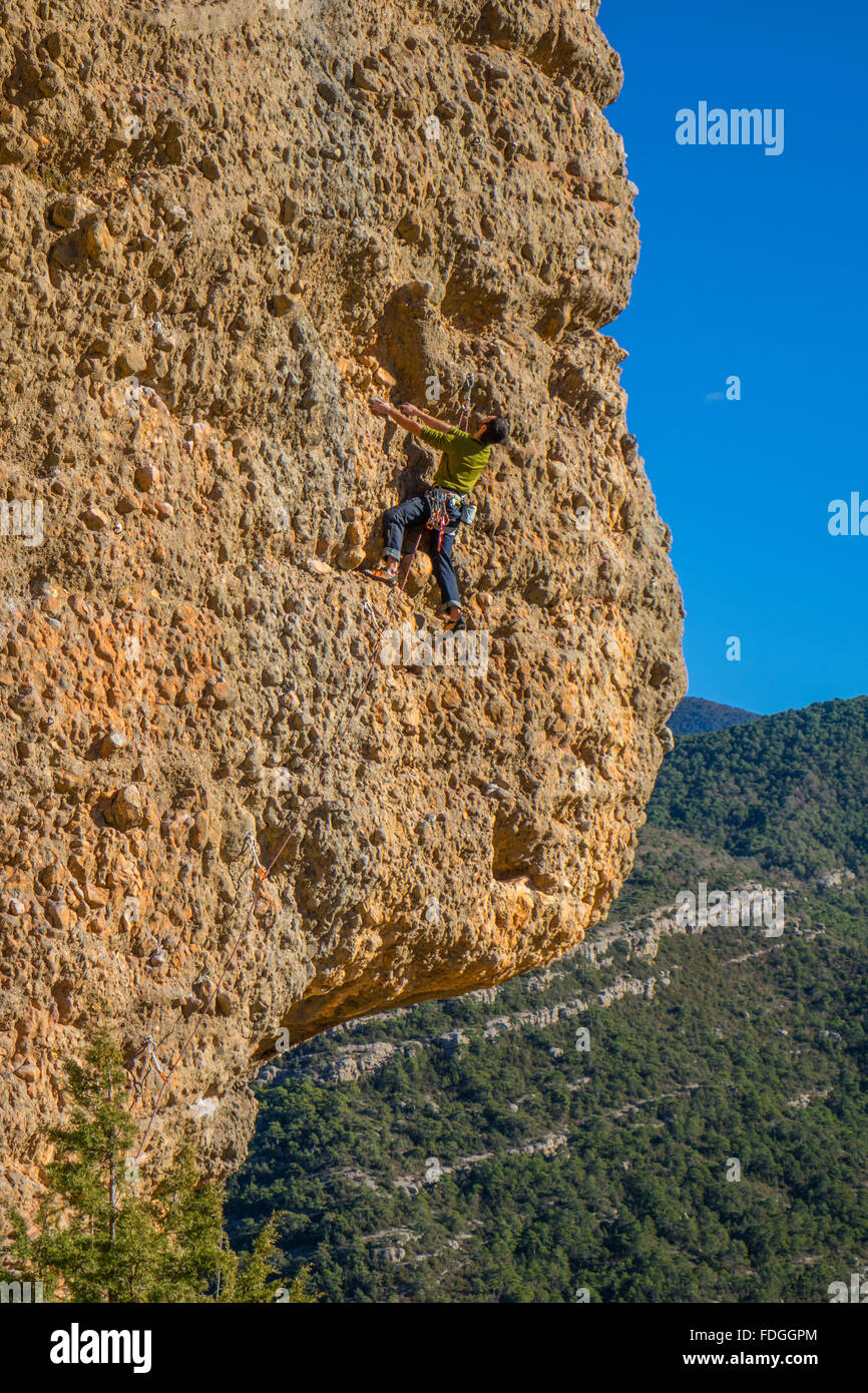 Rock climber on sheer cliff face with blue sky Stock Photo