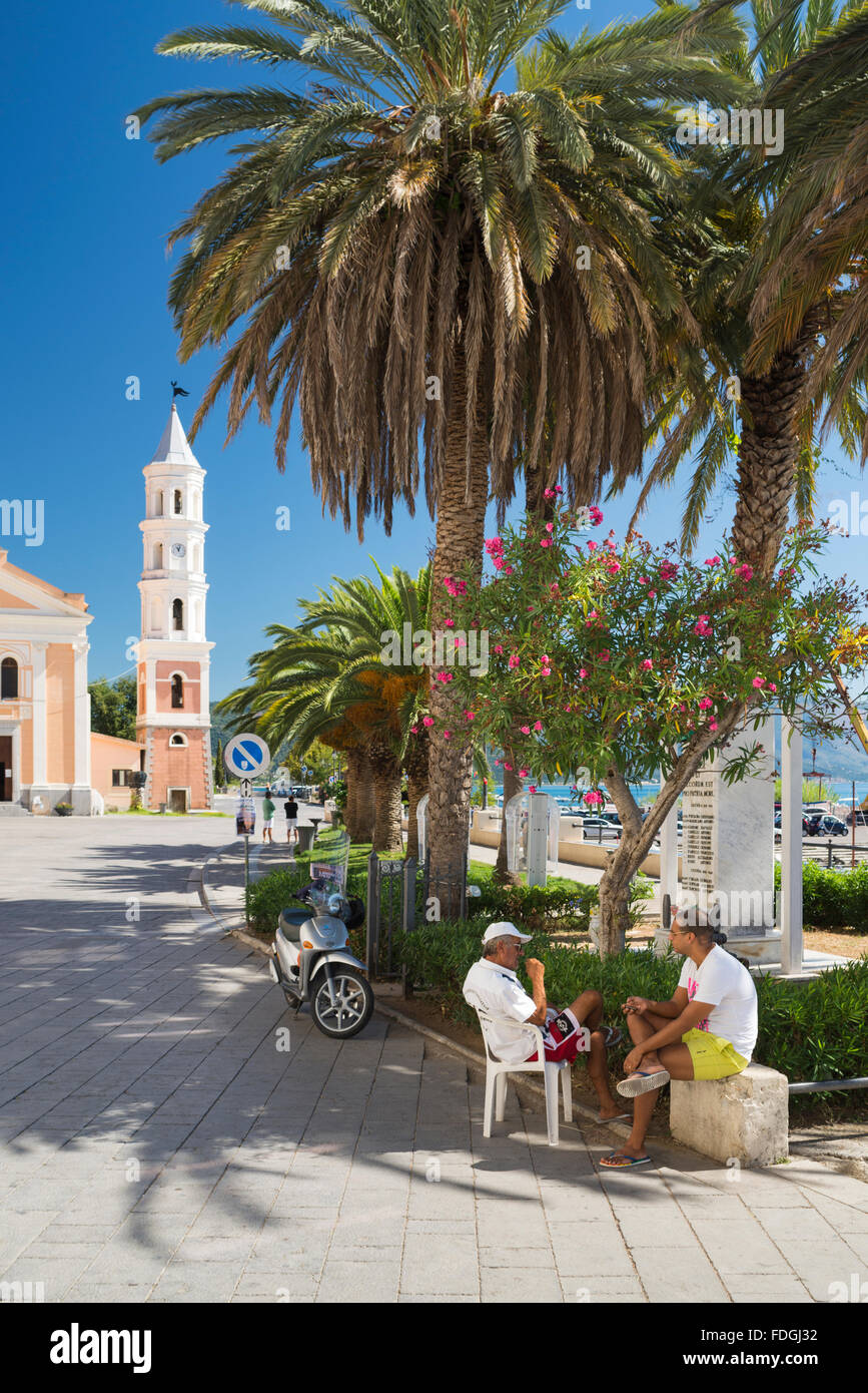 Conversation of two Italian men and local inhabitants in the shade of palm trees in the harbor of Scario,Cilento,Campania, Italy Stock Photo