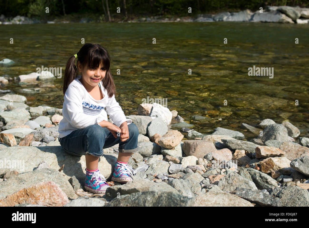 Little girl playing near the river Stock Photo - Alamy