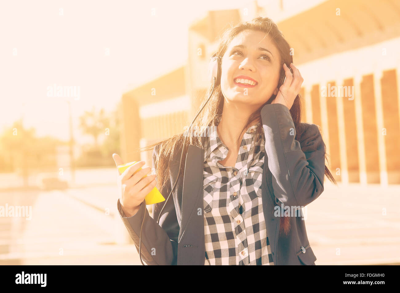 a girl listens to music in the street from her smartphone Stock Photo