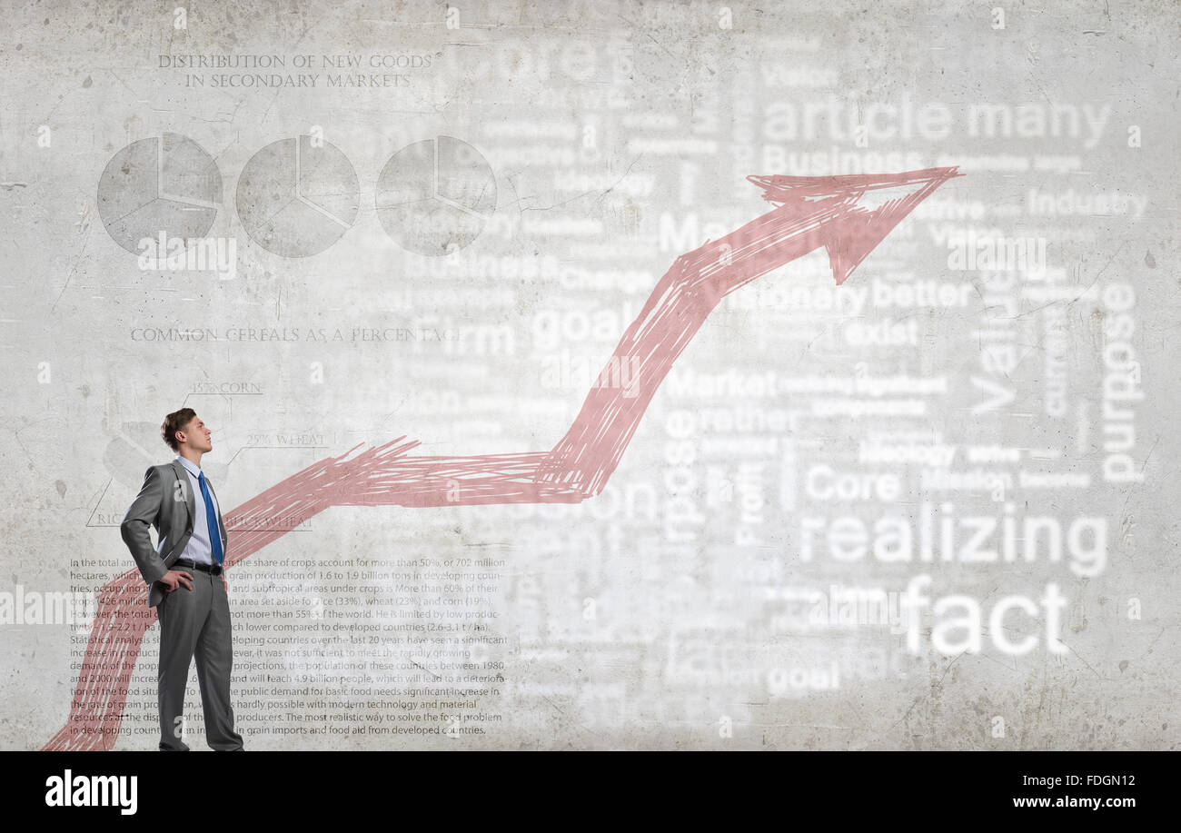 Confident businessman with arms on waist and red growing arrow graph ...