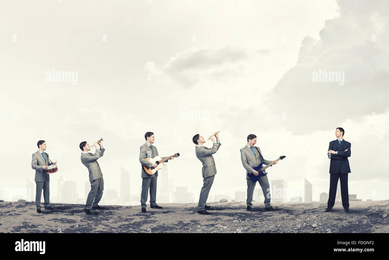 Man orchestra in suit playing different music instruments Stock Photo ...
