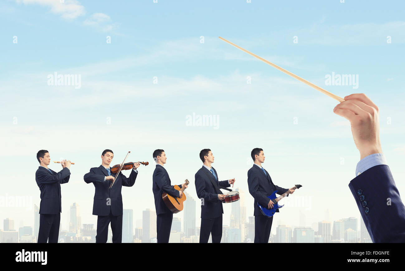 Man orchestra in suit playing different music instruments Stock Photo ...