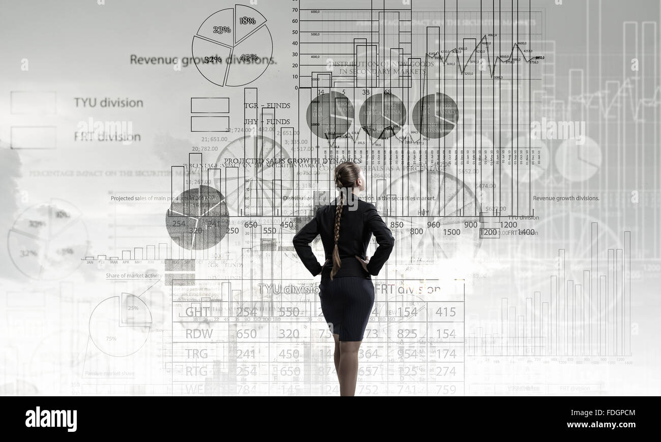 Rear view of businesswoman looking at infographs on wall Stock Photo ...