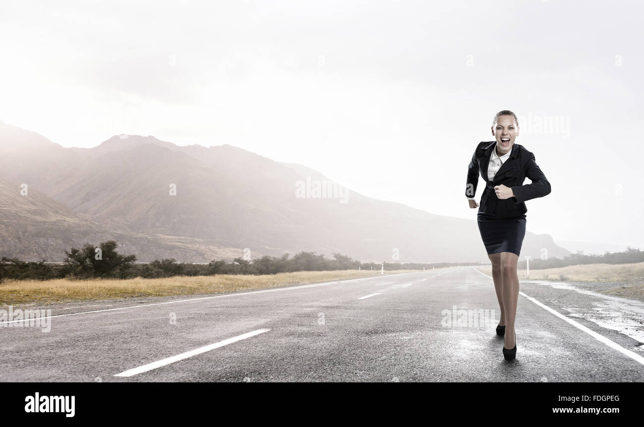 Young determined businesswoman competitor running on road Stock Photo ...