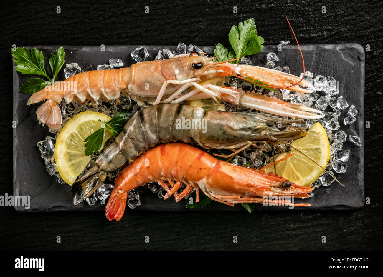 Prawns and lobster served on black stone Stock Photo