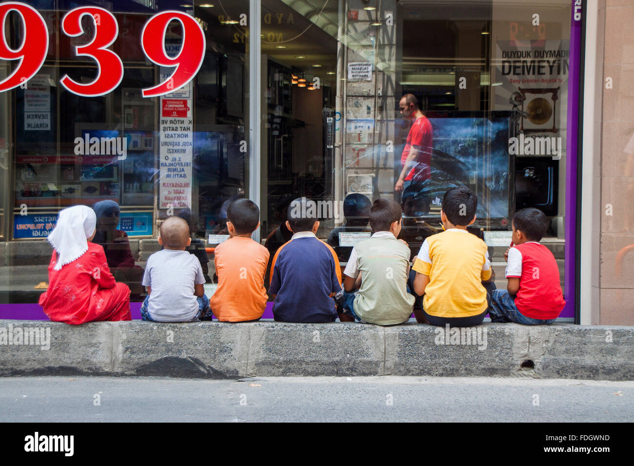 Children staring at television in a TV shop in Fatih neighborhood ...