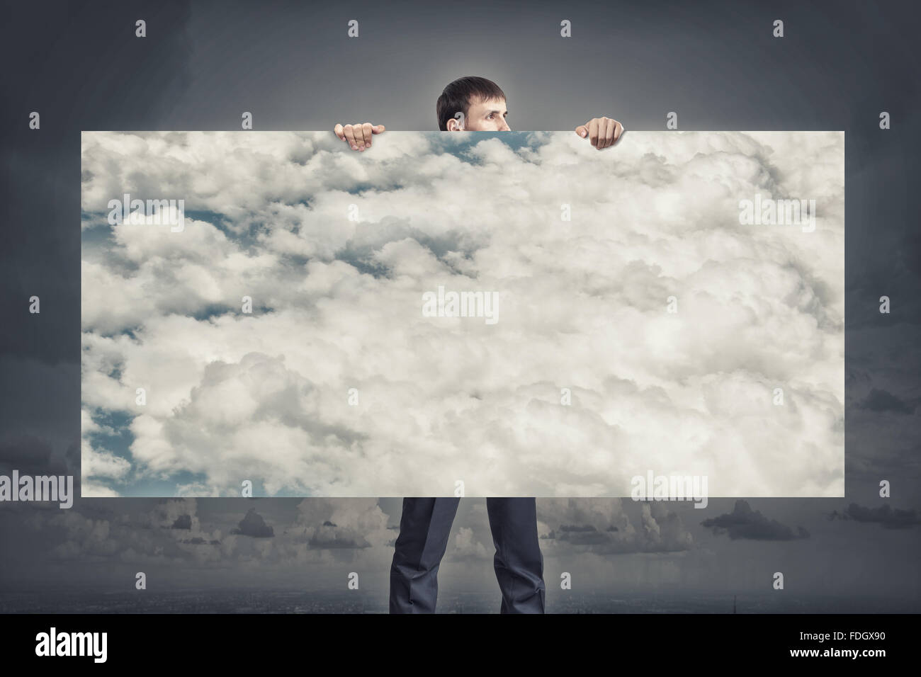 Young businessman holding banner with blue cloudy sky Stock Photo - Alamy