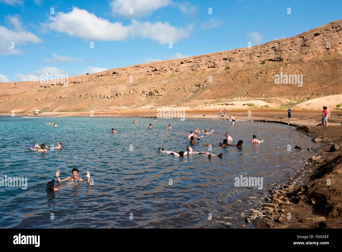Horizontal view of tourists floating in the salt crater on Sal, in Cape Verde. Stock Photo