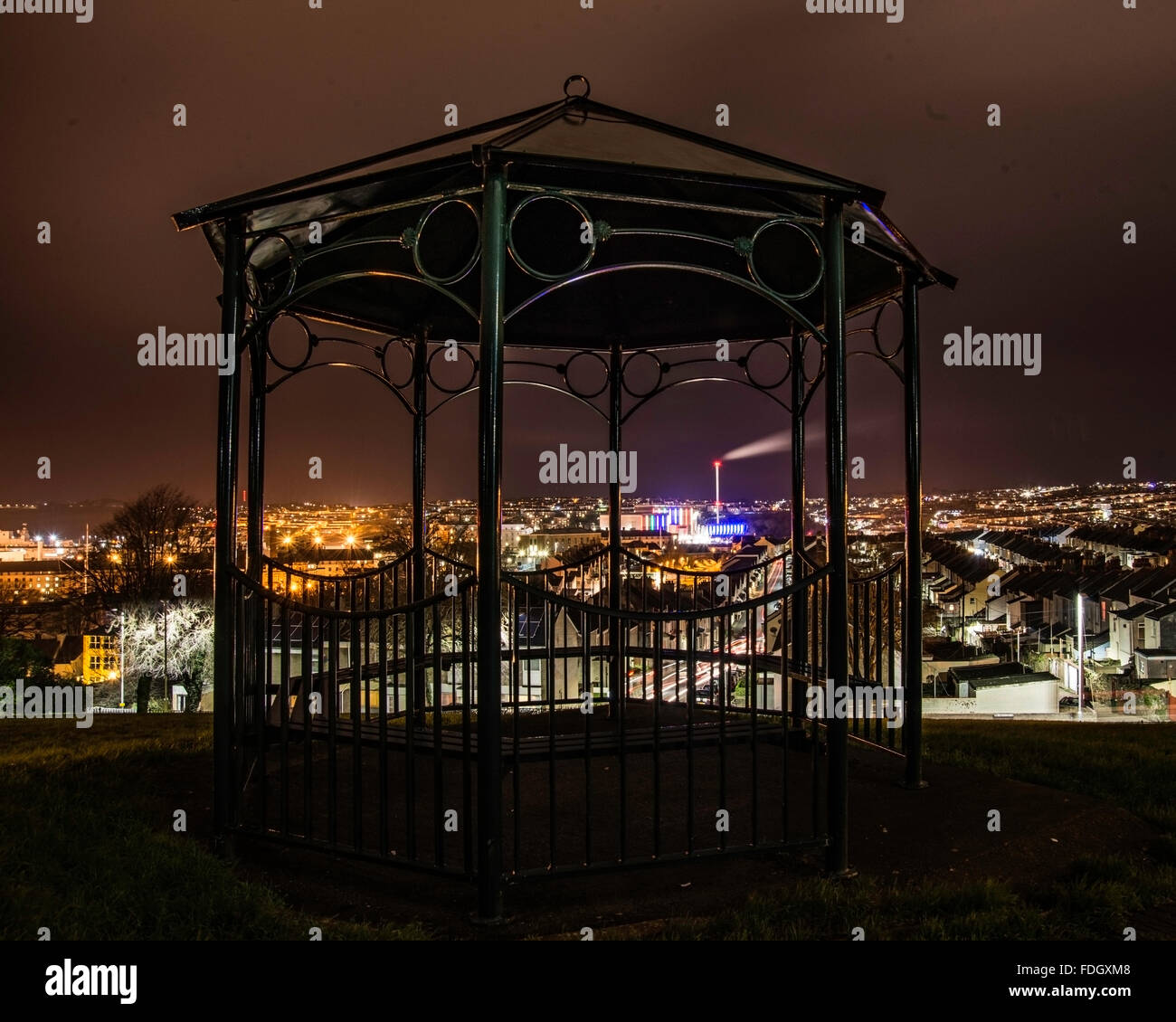 Nightime view over North Plymouth showing the Incinerator, taken through a bandstand in a park. Stock Photo